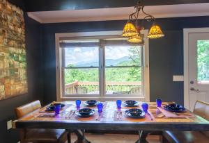 a dining room with a table and a window at Misty Mountain Cabin in Lenoir