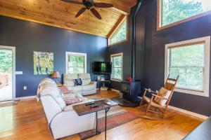 a living room with a white couch and a ceiling fan at Misty Mountain Cabin in Lenoir