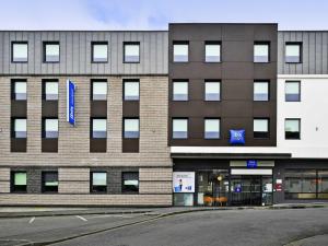 a large brick building with windows on a street at ibis budget Saint-Quentin Centre Gare in Saint-Quentin