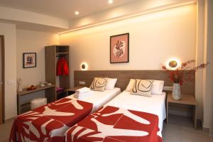 a hotel room with two beds with red and white blankets at Luz House Marbella Hostal in Marbella