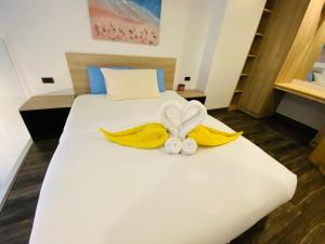 a white bed with yellow blankets and towels on it at Utopia Loft in Rawai Beach