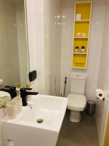 a white bathroom with a toilet and a sink at Utopia Loft in Rawai Beach
