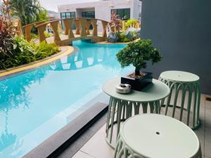 a bonsai tree sitting on two tables next to a swimming pool at Utopia Loft in Rawai Beach