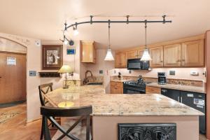 a kitchen with wooden cabinets and a large island at Telemark Lodge #504 in Copper Mountain