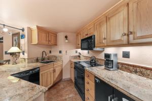 a kitchen with wooden cabinets and black appliances at Telemark Lodge #504 in Copper Mountain