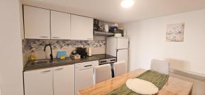 a kitchen with white cabinets and a table and a sink at Elis in Hrašćina +17 photos