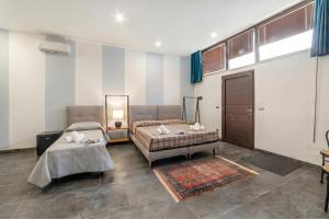 a living room with two beds and a rug at Tenuta VillaMar Rooms in Cursi