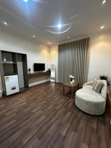 a living room with a couch and a television at غرف خاصة مودرن in Hail +4 photos