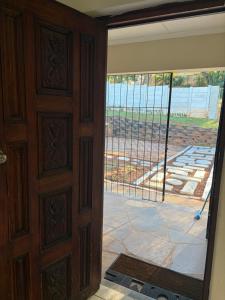 an open door with a view of a patio at Garden Cottage - Self Catering in Amanzimtoti