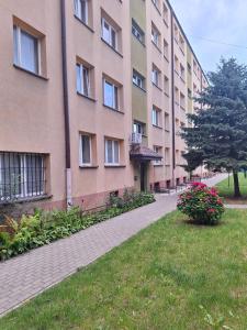 a large building with a sidewalk next to a yard at Exclusive Apartament Centrum 45m in Tarnów