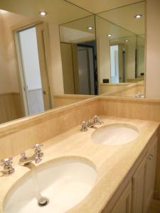 uma casa de banho com 2 lavatórios e um espelho grande em Villa vista Fiesole em Florença