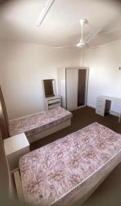a room with two beds and a tv in it at Amr home in Amman