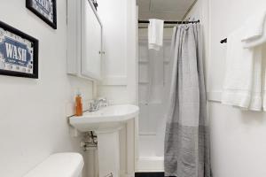 a white bathroom with a sink and a shower at Lower A-Frame Escape in Ludlow +17 photos