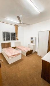 a room with two beds and a tv in it at Amr home in Amman