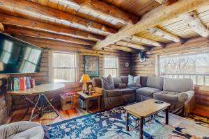 a living room with a couch and a tv in a cabin at The Cabin at Fort Defiance in Barnard