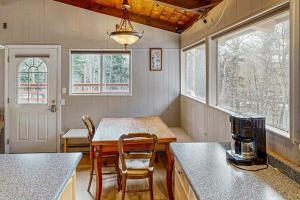 a kitchen with a table and chairs and windows at The Last Run in Wardsboro