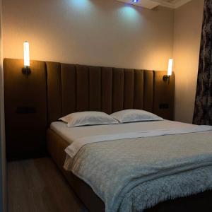 a bedroom with a large bed with two pillows at Three Star in Almaty
