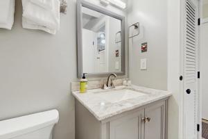 a white bathroom with a sink and a mirror at North Lynx 11 in Warren +27 photos