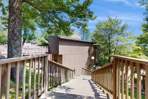 a wooden walkway leading to a building with a tree at North Lynx 11 in Warren