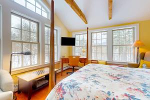 a bedroom with a bed and a desk and windows at Timberbrook in Dorset