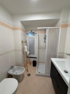 a bathroom with a shower and a toilet and a sink at Lauro Apartment in Meta