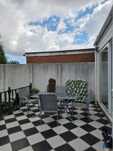 a patio with a table and chairs on a checkered floor at Margate beach house in Margate