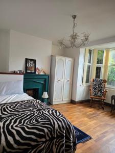 a zebra print bed in a bedroom with a chair at Margate beach house in Margate