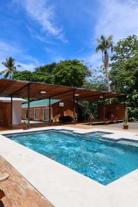 a swimming pool in front of a house at Villa Republik in Parrita