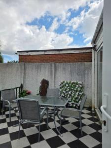 a patio with a table and chairs and a fence at Margate beach house in Margate