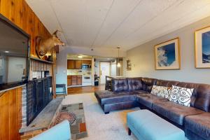 a living room with a brown leather couch at Mountain Green - 2E3 in Killington