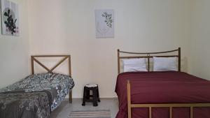 a bedroom with two beds and a night stand at Katty House in Santa Bárbara de Samaná