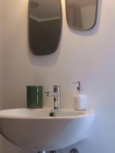 a bathroom sink with two mirrors on the wall at Tolomeo's House-Bed & Bike in Nardò