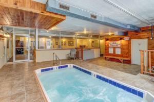 a large indoor swimming pool in a room with a bar at Cozy Mountainside Condo in Waitsfield