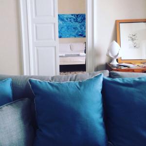 uma sala de estar com um sofá com almofadas azuis em Tolomeo's House-Bed & Bike em Nardò