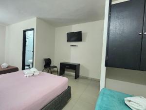 a bedroom with a bed and a desk and a television at Hotel Bocagrande Cartagena in Cartagena de Indias