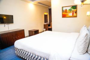 a hotel room with a bed and a flat screen tv at Milson Hotel in Naran