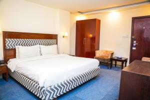 a hotel room with a bed and a chair at Milson Hotel in Naran