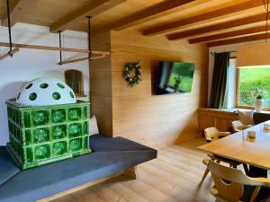 a room with a dining table and a green stove at Ferienhaus Eichenseer Gallzein - Alleinlage mit Garten, Wald & Bergblick in Gallzein +39 photos