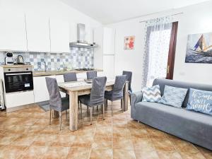 a kitchen and living room with a table and a couch at Villa Angedras in San Teodoro
