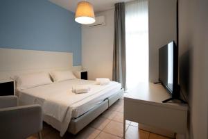 a bedroom with a bed and a flat screen tv at Hotel Minerva in Caorle