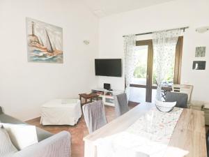 a living room with a table and a tv at Villa Angedras in San Teodoro