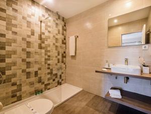 a bathroom with a sink and a toilet and a tub at Villa Waterside in Luz +23 photos