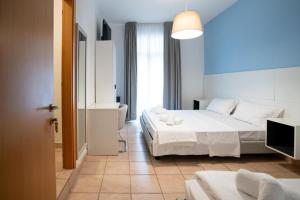 a hotel room with two beds and a bathroom at Hotel Minerva in Caorle