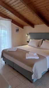 a large bed with two towels on top of it at Sunflower Apartments & Studios in Laganas +28 photos