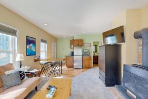 a living room with a couch a table and a kitchen at Ski Ya Later in Proctorsville