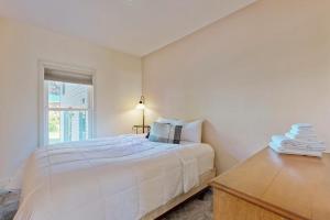 a white bedroom with a bed and a desk at Ski Ya Later in Proctorsville
