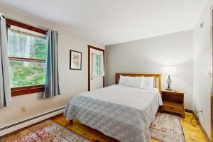 a white bedroom with a bed and a window at Quechee Hollow 2C in Quechee +79 photos