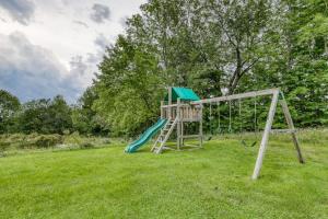a playground with a slide in a field at Log Cabin with a View in Andover