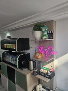 a shelf with a microwave and a sign that reads the one at one hostel in Tabarka