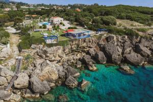 an aerial view of a resort with blue water and rocks at Villa Cleo Periyali in Vasilikos